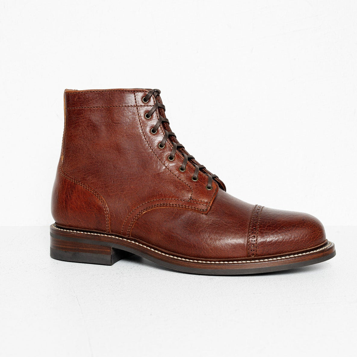 A single dark brown leather lace-up ankle boot with contrast stitching and a dark sole, photographed from the side against a clean white background.